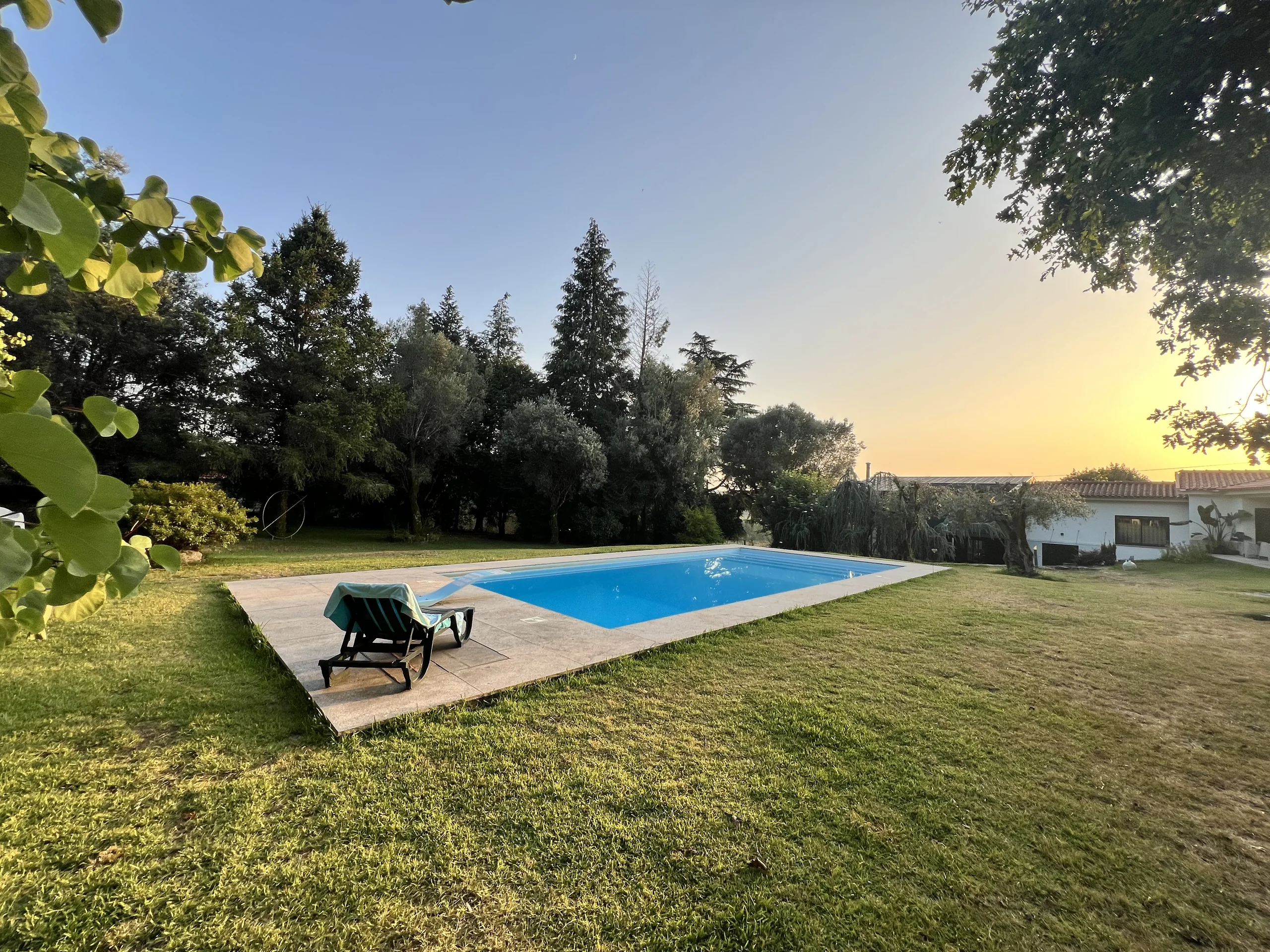 Piscina e jardim das Raízes das Manas ao pôr do sol